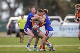 Giants co-coach Jack Duck cops is going nowhere after being wrapped-up by two Bulldogs in a tackle. Picture by James Wiltshire
