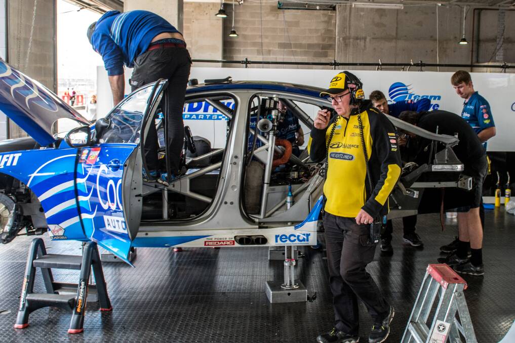 ALL HANDS ON DECK: Brad Jones during the rebuild of his son Macauley's car at Bathurst last year following a crash in the opening practice session. 