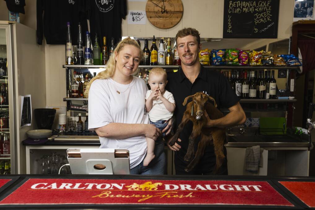 Molly, with daughter Ivy, 1, and brother Dan Middleton, holding Ziggy the goat, are eager to welcome back patrons to Bethanga Hotel after taking over the pub following the death of their mother, Kate, last year. Picture by Ash Smith
