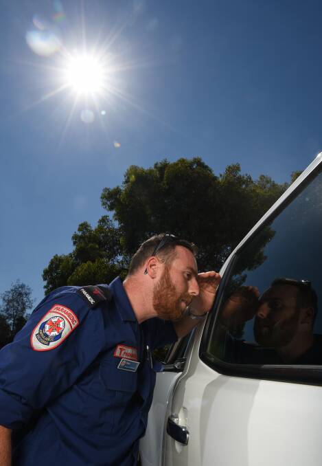 CAR CHECK: Wodonga advanced life support paramedic Peter Greenall peers through a car window on a hot December day. Picture: MARK JESSER