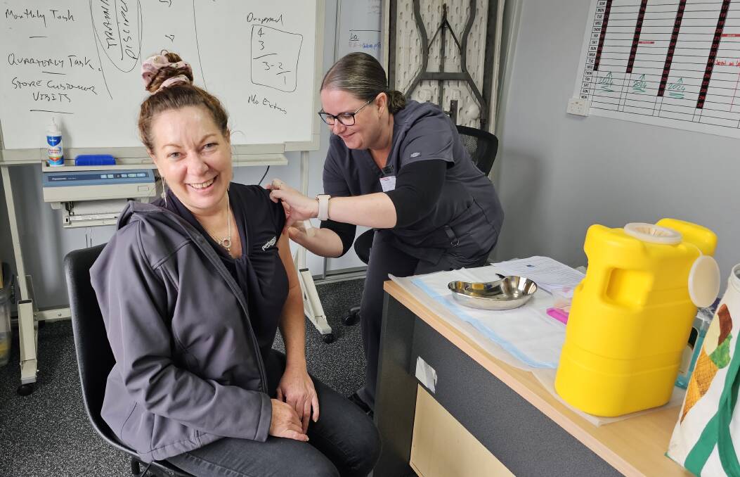 Ron Finemore Transport staff member Lee-Anne (left) receives her flu vaccination at the Wodonga depot. Picture supplied.