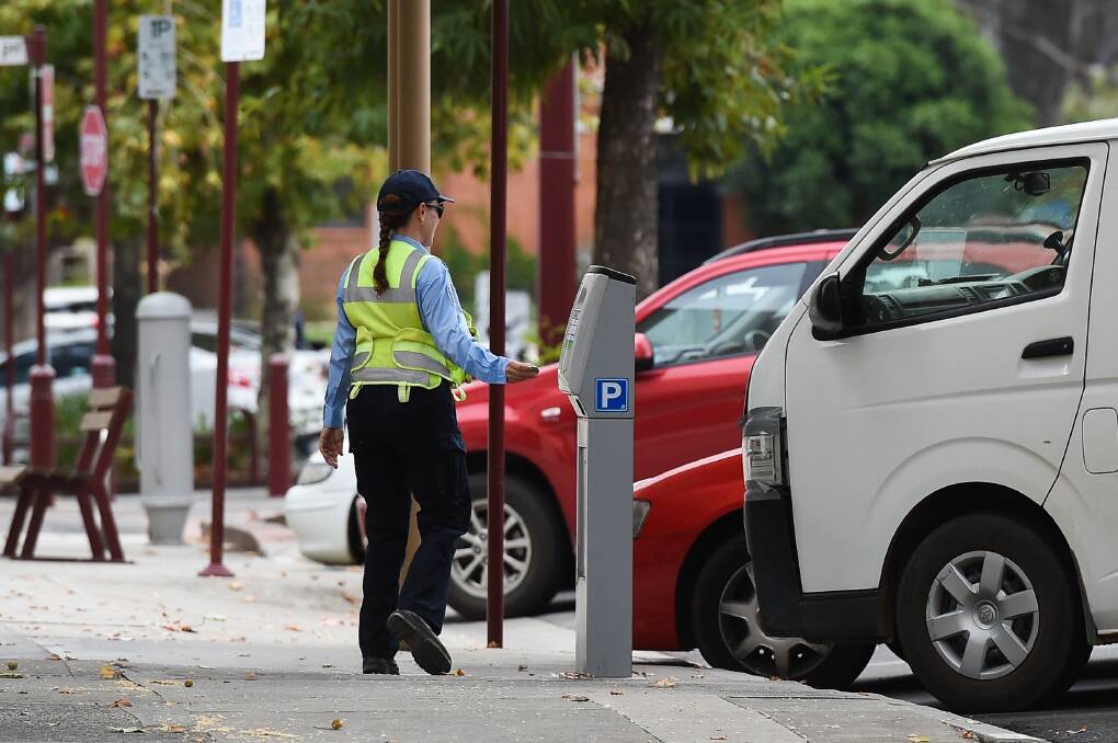 A parking inspector checks cars in Wangaratta. 2018. 