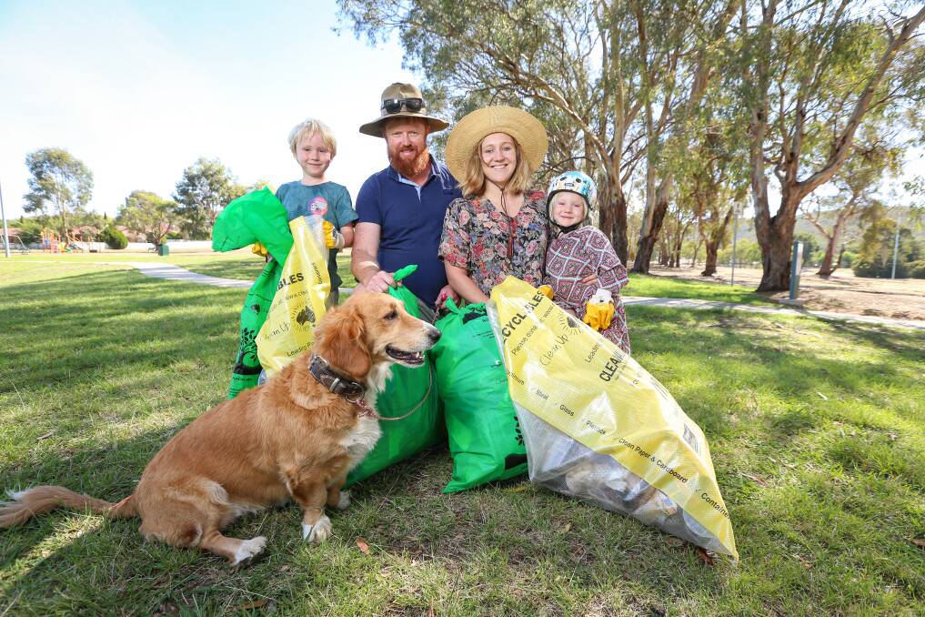 LESSONS TO LEARN: Sam and Nonie Giblin with children, Fred, 6, Margo, 4, and Poh the dog collect rubbish for Clean Up Australia Day near Bonnie Doon Park. Picture: JAMES WILTSHIRE 