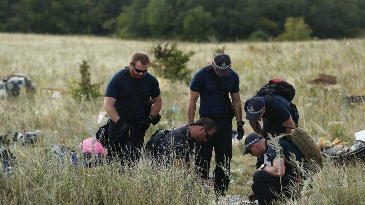 Australian Federal Police officers and their Dutch counterparts collect human remains from the MH17 crash site in the self proclaimed Donetsk Republic, Ukraine on 2 August, 2014. Photo: Kate Geraghty
