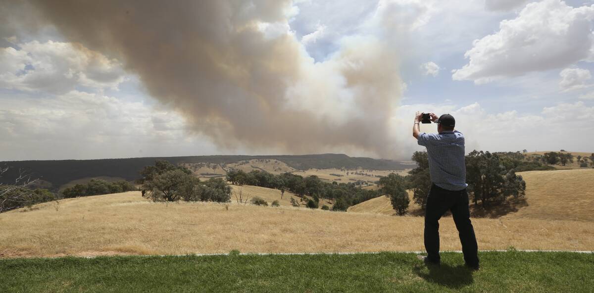 SNAPSHOT: An onlooker takes a snap at the top of the Indigo Valley as the fire makes its way towards Yackandandah. Picture: ELENOR TEDENBORG