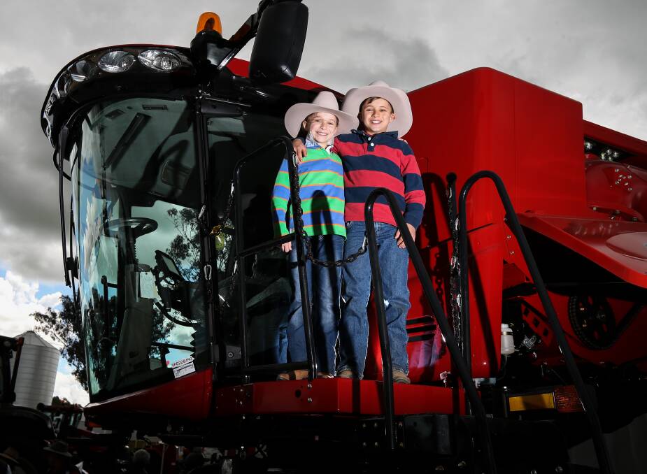 SMILES: Myer and Roan Patten travelled from Leeton for the opening day of the event and inspected a range of machinery, including this large red header. 