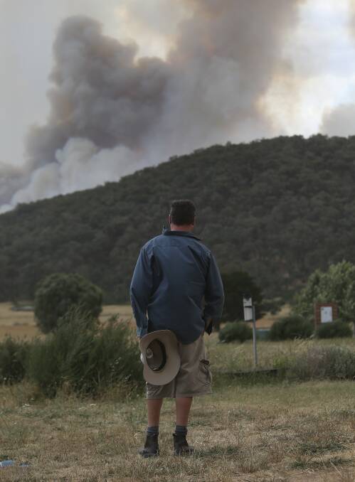 WATCHING: Glen Stewart looks on at the fires at Wooragee on Sunday. 
