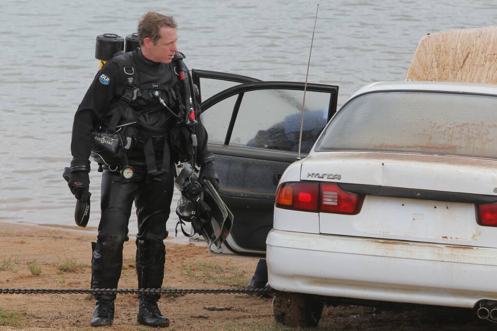 ABANDONED: A police diver looks over the car after helping to retrieve it. Picture: BLAIR THOMSON
