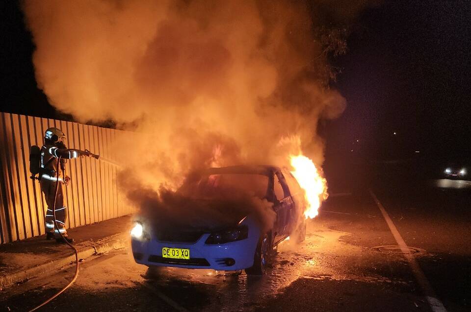 Firefighters extinguish the blaze on Pearsall Street in Lavington on Monday morning. The vehicle is similar to a car linked to a Wodonga fight in which a man's jaw was broken. Picture supplied