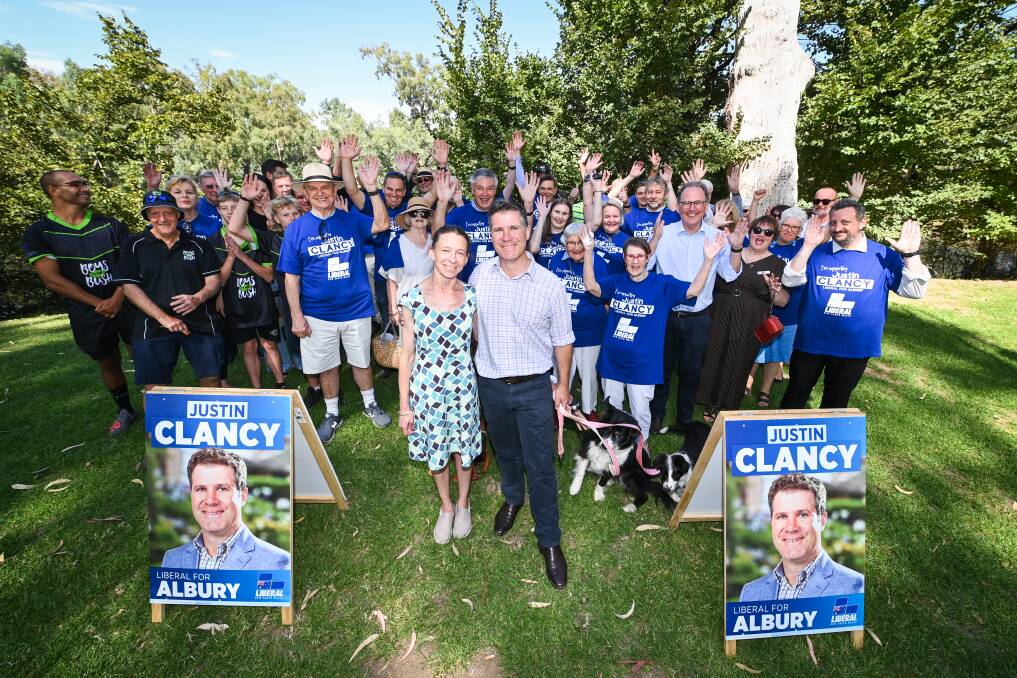Justin Clancy and his wife Tabitha with his supporters alongside the Murray River after his campaign launch. Among those gathered there were border collies Bonnie and Nellie who normally spend their days on a farm at Moorwatha between Howlong and Burrumbuttock. Picture by Mark Jesser.