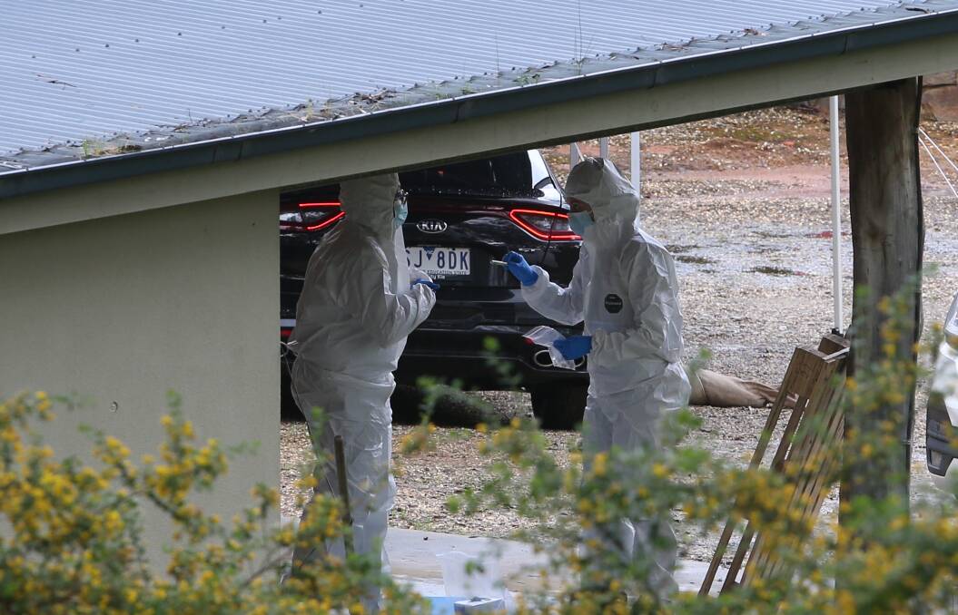 Police investigators assess the scene at the Buckland Gap Road property.