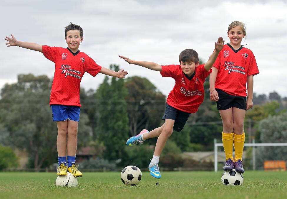  Noah Graham, 9, Brodie Davies, 9 and Ava Tuksar, 9, helping to promote the junior soccer clinic. Picture: BEN EYLES