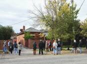 About 40 gathered at 438 Olive Street for the auction of a red brick house on Saturday, May 11. Picture by Mark Jesser